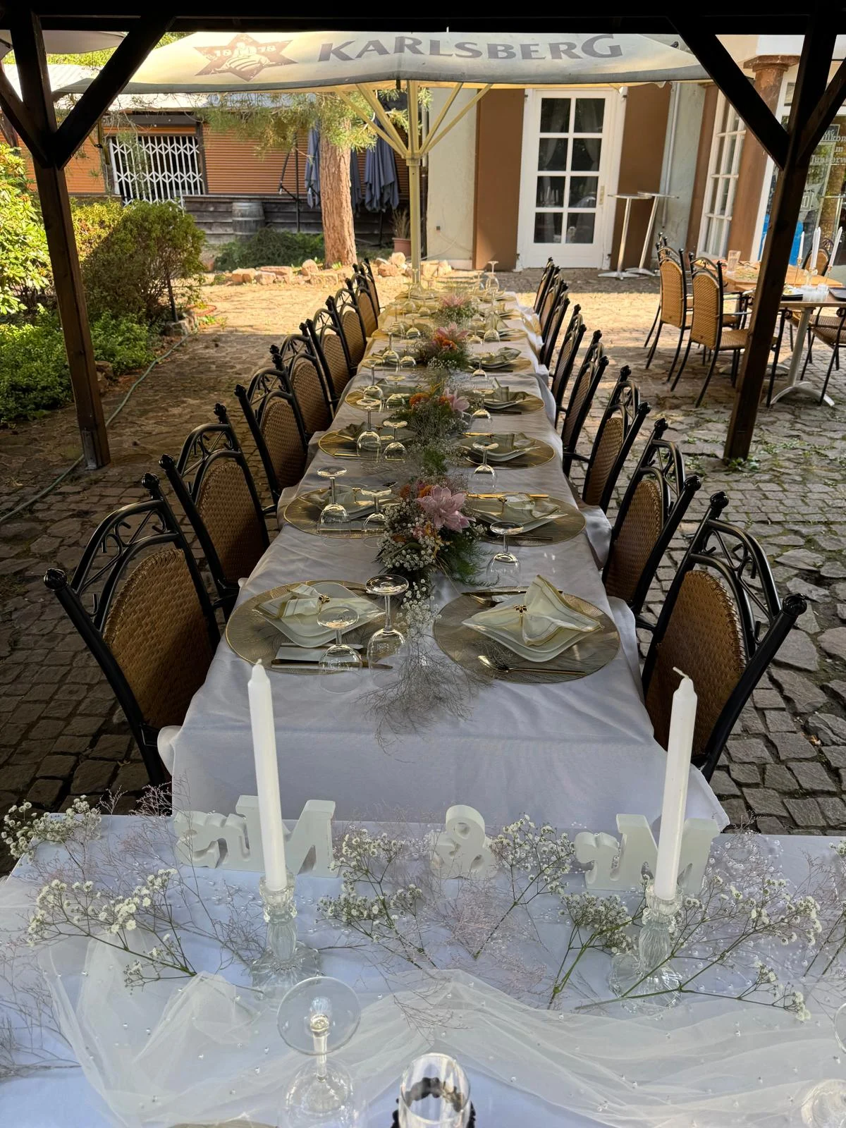 Lange festlich gedeckte Tafel mit Stühlen und floraler Tischdekoration